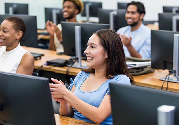 A classroom full of male and female students, each with their own computer.