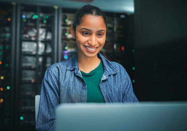 A female student using a computer in a server room.